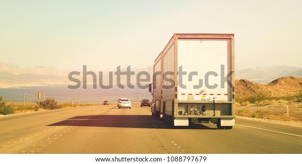 Truck and cars on US highway route on with\
afternon sunlight