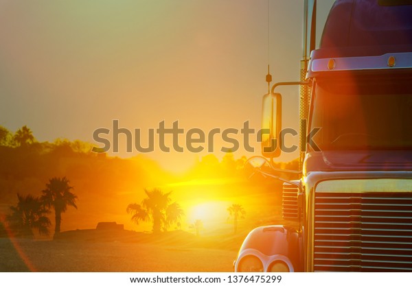 Truck dashboard with on the countryside road in\
motion against with\
sunset