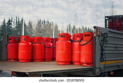Truck deliver hazard goods, carrying red cylinders with compressed gas to customers. Delivering gas cylinders.Truck carrying gas cylinders. - Shutterstock ID 2018788505