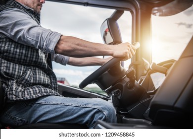 Truck Driver Behind The Wheel. Semi Truck Driving And Transportation Industry.