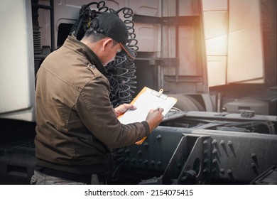 Truck Driver Is Checking The Semi Truck's Maintenance Checklist. Mechanic Repairman Auto Service Shop. Inspection Safety Before Driving. Freight Truck Transport.	
