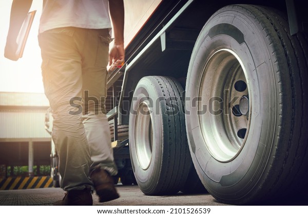 Truck Driver is Checking the Truck\'s Safety\
Maintenance Checklist. Inspection Truck Safety. Semi Truck Wheels\
and Tires.	\
