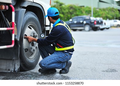 The Truck Driver Checks The Tire Pressure Gauge Truck