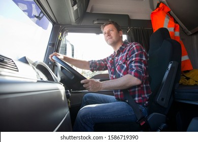 Truck driver driving in cab of semi-truck