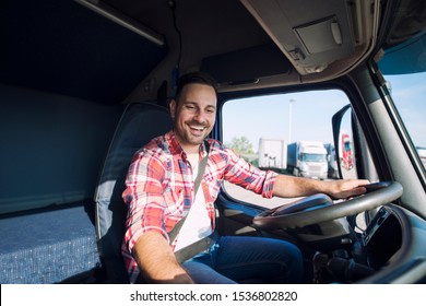 Truck Driver Driving His Truck And Changing Radio Station To Play His Favorite Music. Trucker Enjoying His Job. Transportation Services.