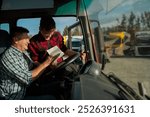 Truck driver and fleet manager smiling, taking and planning route or signing contract 