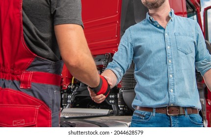 Truck Driver and His Mechanic Hand Shaking in Front of Modern Semi Truck Tractor. Heavy Transportation Industry Theme.