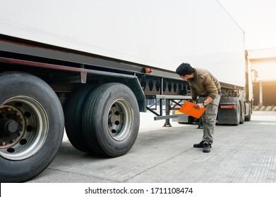 Truck Driver Holding Clipboard Is Checking The Truck's Safety Maintenance Checklist. Mechanic Repairman Shop. Inspection Of Semi Truck Wheels Tires.Shipping Cargo Freight Truck Transport Logistics.