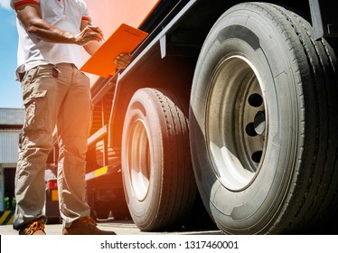 Truck Driver Holding Clipboard With Inspect Truck Tire, Inventory And Safety Check.