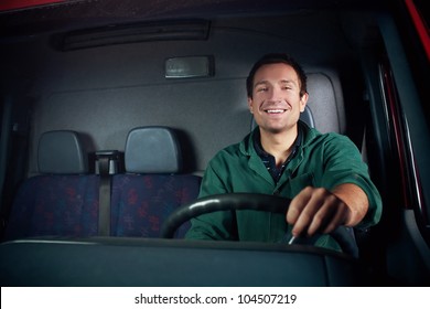 Truck driver holding wheel. Smiling at work