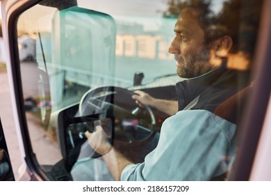 Truck Driver Looking At Side Mirror While Parking In Reverse. 