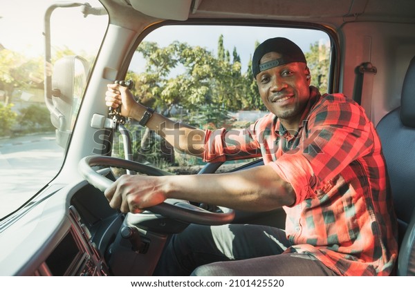 Truck Driver man African American muscular\
smiling, in long-time business transportation and delivery. Trust\
by customers  provide professional service and safety in transport\
Truck Insurance cargo.