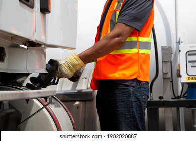 Truck Driver Refuelling Transport Truck Wearing Safety Vest