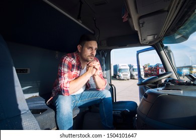 Truck Driver Sitting In His Cabin And Thinking About His Family. Trucker Missing His Family Being Sad. Truck Driver Lifestyle.