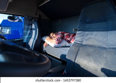 Truck Driver Sleeping On Bed Inside Truck Cabin Interior. Trucker Lifestyle.