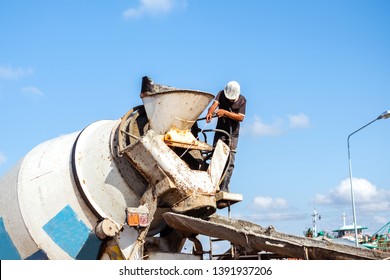 Truck Driver Washing The Cement Mixer Truck With Water Jet After Finish Pouring Cement. Heavy Equipment Machinery For Heavy Industry Concept.