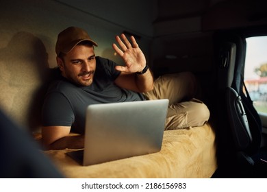 Truck Driver Waving To Someone During Video Call From His Vehicle Cabin. 