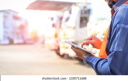 Truck drivers hand holding tablet checking the product list,Driver writing electronic log books,spot focus.