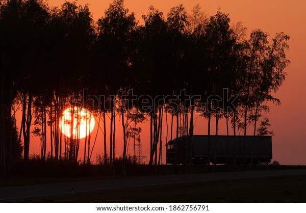 \
the truck is driving against the backdrop of the\
setting sun