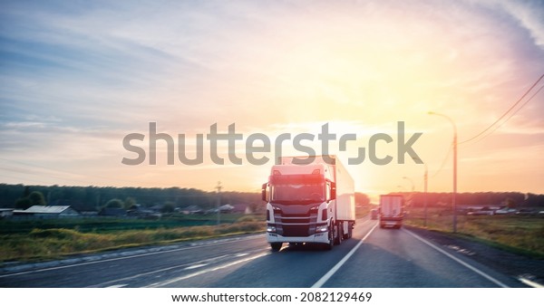 Truck\
driving on asphalt road in rural russia landscape with sun light,\
concept cargo transportation. Blur move\
effect.