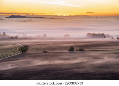 Truck Driving On A Country Road At Sunrise With Mist