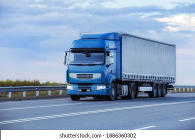 Truck driving on the highway against the background of the cloudy sky