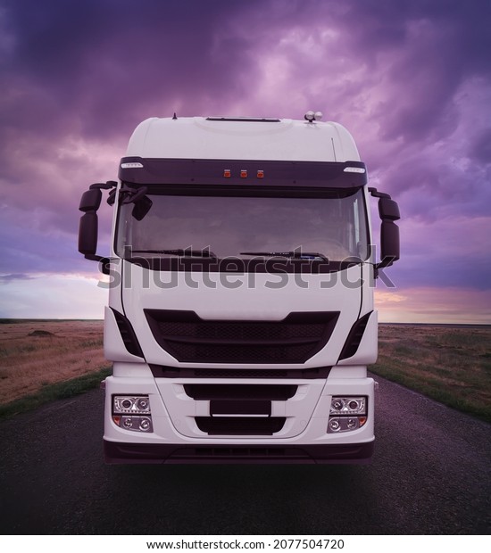 Truck Driving on a Road at Sunset under a Dramatic\
Cloudy Sky