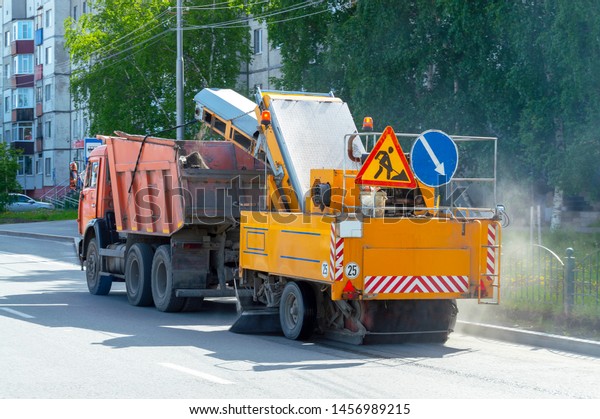 Truck\
dump truck pulls the installation of the wheel - a vacuum cleaner\
on a city street, Surgut, Russia - July 21,\
2019