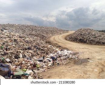 Truck Is Dumping The Gabage From Municipal. The Open Dumping Land Fill With Scaventure And Machine.