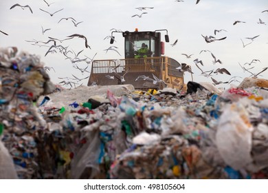 Truck Flattening Household Garbage On A Landfill Waste Site