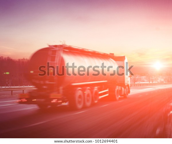 Truck with the\
fuel on winter highway at\
sunset