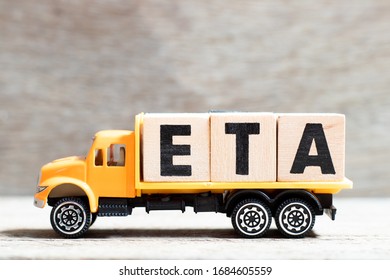 Truck hold letter block in word ETA (abbreviation of estimated time of arrival) on wood background