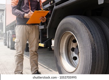 Truck Inspection And Safety. Truck Driver Holding Clipboard Is Checking Wheels Truck.