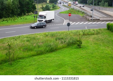 Truck leaves the highway. Car on the street. Roundabout with traffic. - Shutterstock ID 1115331815