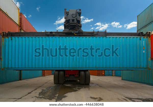 The truck lifts the container. Sea\
container terminal. Storage containers\
area.