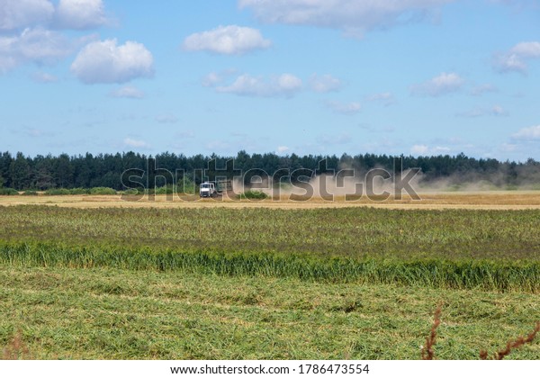 Truck loaded with millet in the countryside,\
driving across the field.