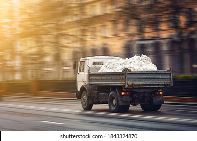 Truck Loaded With Snow Rushes On Road. Charged Dump Truck Take Out Fresh Snow From Snowy City Streets In Winter. Utility Vehicle Cleans Street, Snow Disposal. Truck Removal Of Snow, Cleaning Work