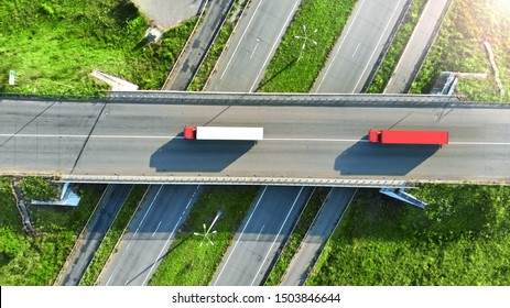 Truck Logistic Aerial. Two Trucks Motion By The Highway Intersection Road Between Fields. View From Drone.