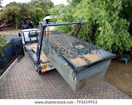 Truck (lorry) loading a full skip waste management container