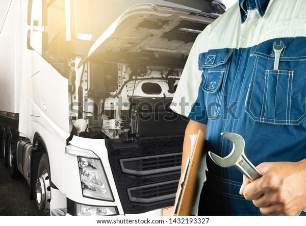 Truck\
maintenance and repairing. Professional auto mechanic holding\
wrench is maintenance the engine semi\
truck.