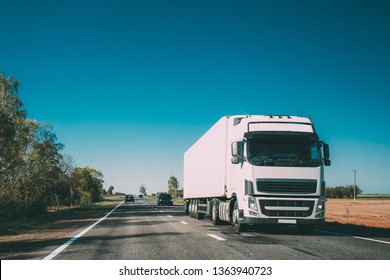 Truck In Motion On Country Road. Tractor Unit, Prime Mover, Traction Unit In Motion On Countryside Road In Europe. Business Transportation And Trucking Industry Concept