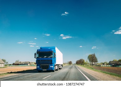 Truck In Motion On Country Road. Tractor Unit, Prime Mover, Traction Unit In Motion On Countryside Road In Europe. Business Transportation And Trucking Industry Concept
