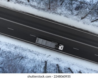 Truck in motion on road in winter, top view of road with truck blurred by traffic - Shutterstock ID 2248060935