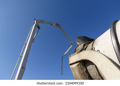 Truck Mounted сoncrete Pump And Concrete Mixer At A Construction Site. Concrete Pouring Process.
Element Of Unfolded Hydraulic Boom Machine On Blue Sky Background. Construction Work Concept.