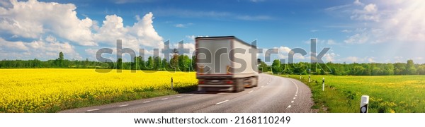 Truck\
moving on the asphalt country highway in sunny day in spring.\
Concept of logistic and freight\
transportation.