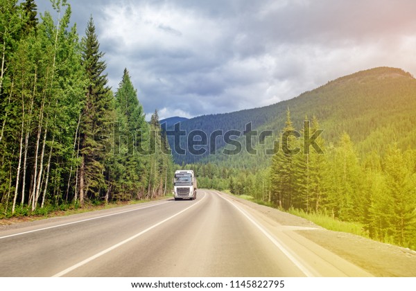 The truck is\
moving on the mountain forest\
road