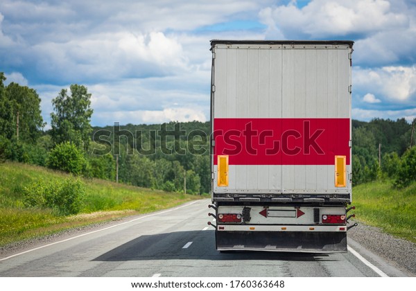 A  truck with the national flag of Poland depicted on\
the back door carries goods to another country along the highway.\
Concept of export-import,transportation, national delivery of goods\
