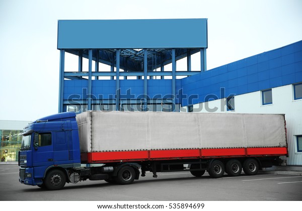 Truck on car parking near warehouse. Delivery\
and shipping concept.