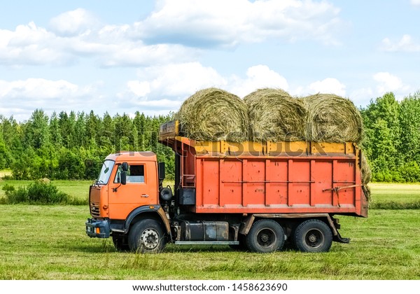 truck on the field\
in the back of hay rolls