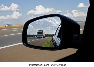 Truck on a highway seen in the rear view mirror on a summer day.           